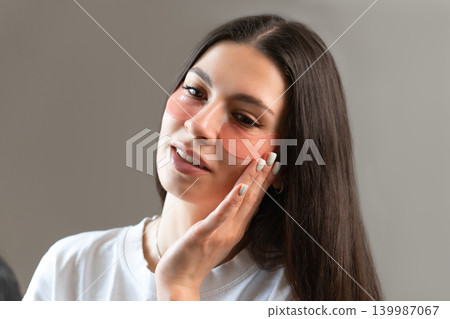 Young woman relaxing with hydrogel under-eye patches during daily skincare routine at home. Natural beauty portrait focused on self-care, healthy skin and modern cosmetic treatment. Young woman relaxing with hydrogel under-eye patches during daily skincare routine at home. Natural beauty portrait focused on self-care, healthy skin and modern cosmetic treatment. 139987067