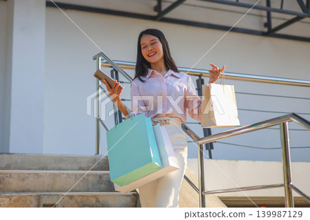 Happy young Asian women shopping gift for holiday, carrying colourful shopping bags. Happy young Asian women shopping gift for holiday, carrying colourful shopping bags. 139987129