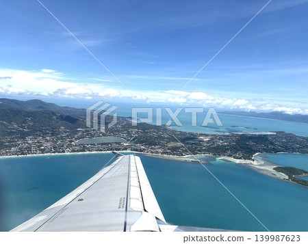 A view of a flight to a tropical paradise from an airplane. 139987623
