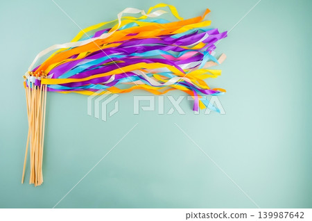 Colorful Rainbow Ribbon Wand with Wooden Sticks on Light Blue Background Colorful Rainbow Ribbon Wand with Wooden Sticks on Light Blue Background 139987642