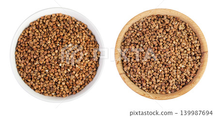 Raw buckwheat in ceramic and wooden bowl isolated on white background. Top view. Flat lay Raw buckwheat in ceramic and wooden bowl isolated on white background. Top view. Flat lay 139987694