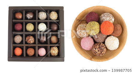 A variety of different truffles in a box and wooden bowl Isolated on a white background. Top view. Flat lay A variety of different truffles in a box and wooden bowl Isolated on a white background. Top view. Flat lay 139987705