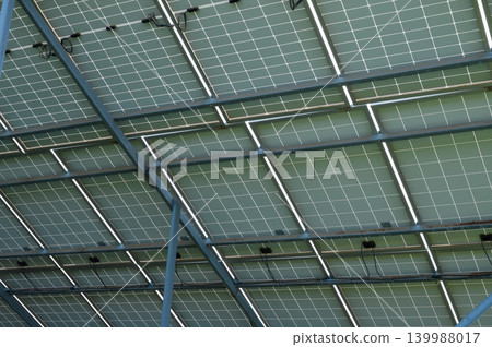 Solar panels glistening under the sun, reflecting sustainable energy solutions above a modern building 139988017