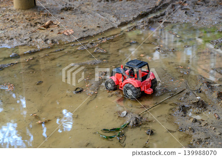 Toy tractor in puddle close-up Toy tractor in puddle close-up 139988070
