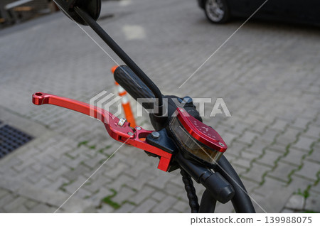 Hydraulic motorcycle brake lever with red adjustable handle close-up Hydraulic motorcycle brake lever with red adjustable handle close-up 139988075