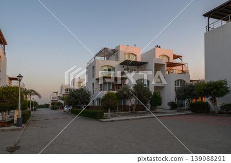 Sunset casts a warm glow on modern architecture in a coastal neighborhood Sunset casts a warm glow on modern architecture in a coastal neighborhood 139988291
