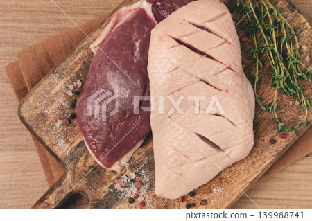 Fresh raw duck breasts, on a wooden chopping board, with herbs and spices, no people Fresh raw duck breasts, on a wooden chopping board, with herbs and spices, no people 139988741