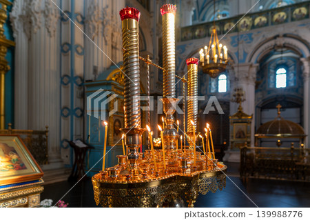 Golden Candle Stand With Lit Candles in Ornate Orthodox Church Interior During Prayer Service Golden Candle Stand With Lit Candles in Ornate Orthodox Church Interior During Prayer Service 139988776