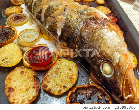 Delicious roasted fish with colorful vegetables on a sunny kitchen table Delicious roasted fish with colorful vegetables on a sunny kitchen table 139989396