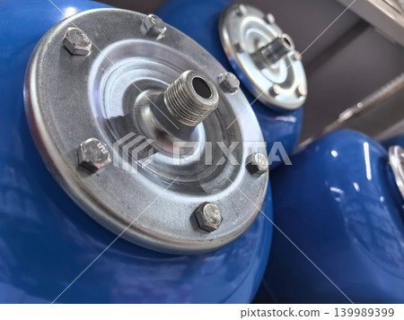Blue tanks with metal details resting on a shelf in a workshop Blue tanks with metal details resting on a shelf in a workshop 139989399
