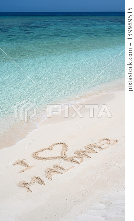 I love Maldives written in the white sand on a tropical beach in Maldives. Vertical photo of turquoise sea water. Travel and ocean vacation concept I love Maldives written in the white sand on a tropical beach in Maldives. Vertical photo of turquoise sea water. Travel and ocean vacation concept 139989515