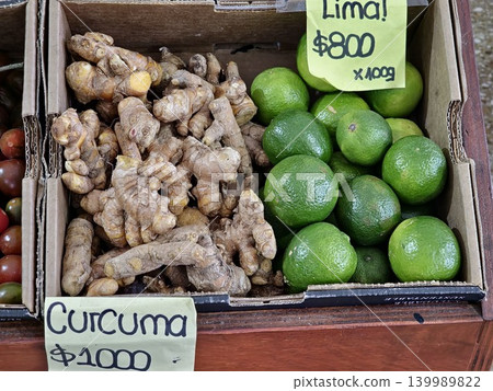 Cordoba, Argentina - April 9, 2026: turmeric and limes displayed in cardboard produce boxes Cordoba, Argentina - April 9, 2026: turmeric and limes displayed in cardboard produce boxes 139989822