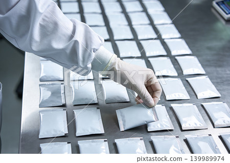 Hand inspecting packaged samples in a sterile laboratory environment Hand inspecting packaged samples in a sterile laboratory environment 139989974