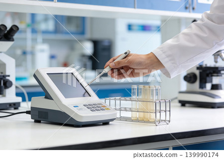 Scientist uses advanced equipment for precise laboratory analysis and research Scientist uses advanced equipment for precise laboratory analysis and research 139990174