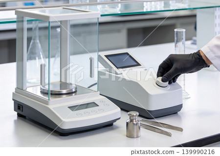 Precision laboratory scales and scientific equipment on a clean white table Precision laboratory scales and scientific equipment on a clean white table 139990216