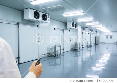 Professional inspecting a sterile cold storage facility with climate control systems Professional inspecting a sterile cold storage facility with climate control systems 139990220