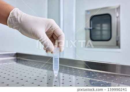 Scientist in sterile gloves holds a sample tube in a laboratory setting Scientist in sterile gloves holds a sample tube in a laboratory setting 139990241
