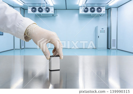Scientist in sterile lab places small device on reflective metal surface Scientist in sterile lab places small device on reflective metal surface 139990315