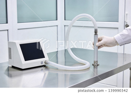 Medical ventilator device with flexible tubing and hand in sterile environment 139990342