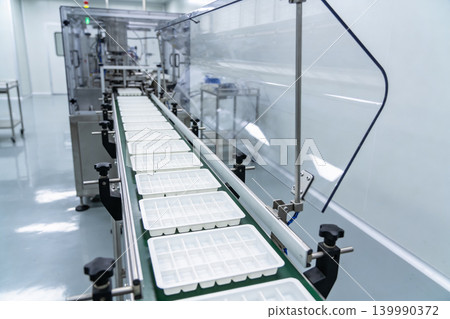 Automated production line with empty trays moving on a conveyor belt 139990372