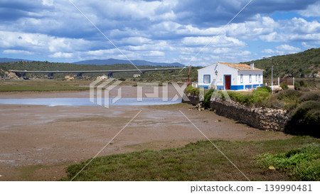 Coastal landscape with a white house and a bridge over a tidal river Arade Portugal 139990481