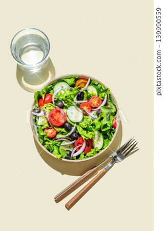 A vegetable salad on a plate on yellow isolated background with shadows. A vegetable salad on a plate on yellow isolated background with shadows. 139990559