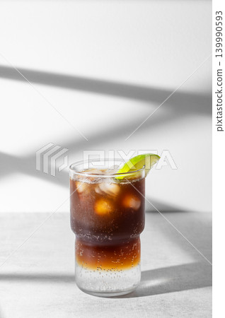 Cold Coffee Tonic Drink With Lime and Ice on light background with shadows 139990593