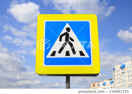 Pedestrian crossing sign on an outdoor metal pole. Informational indicator for ensuring safety on city streets and regulating pedestrian traffic. Pedestrian crossing sign on an outdoor metal pole. Informational indicator for ensuring safety on city streets and regulating pedestrian traffic. 139991785