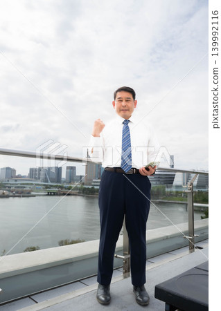 一名男子在屋頂上擺出勝利姿勢。 一名男子在屋頂上擺出勝利姿勢。 139992116