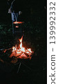 A scene of enjoying a barbecue around a campfire while camping. 139992332