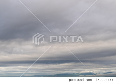遠處是廣闊的層積雲和籠罩在薄霧中的山脈輪廓。 139992733