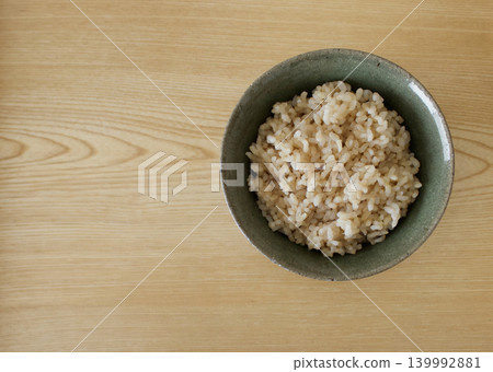 A bird's-eye view of brown rice and the empty space on the wooden board. A bird's-eye view of brown rice and the empty space on the wooden board. 139992881