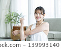 A young woman working out at home, looking directly at the camera. 139993140