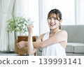 A young woman working out at home, looking directly at the camera. 139993141