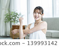 A young woman working out at home, looking directly at the camera. 139993142