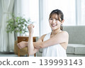 A young woman working out at home, looking directly at the camera. 139993143