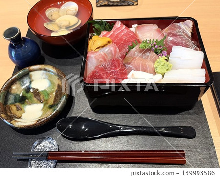 A luxurious Japanese set meal featuring a seafood rice bowl served with a clear soup. A luxurious Japanese set meal featuring a seafood rice bowl served with a clear soup. 139993586