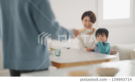 A scene of a family of four eating at the dinner table. A scene of a family of four eating at the dinner table. 139993714