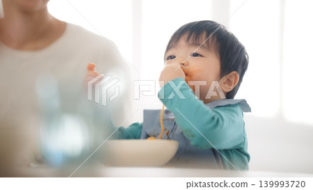 A scene of a family of four eating at the dinner table. A scene of a family of four eating at the dinner table. 139993720