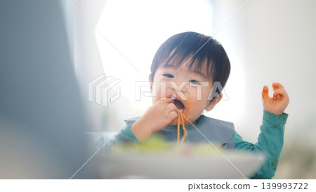 A scene of a family of four eating at the dinner table. A scene of a family of four eating at the dinner table. 139993722