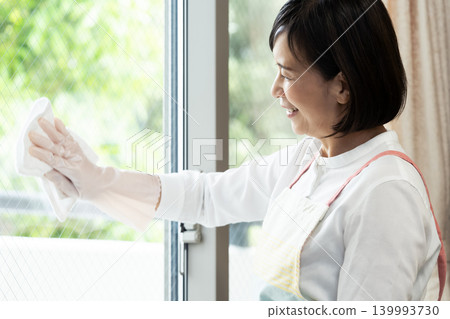 A woman cleaning windows A woman cleaning windows 139993730