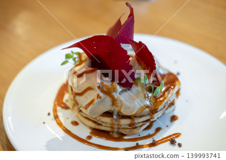 Fluffy pancake stack with cream, and salted caramel sauce, and topped red raspberry tuile 139993741