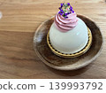 A berry mousse cake garnished with elegant purple flowers. 139993792