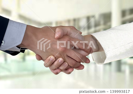 Image of a business person (male or female) shaking hands. 139993817