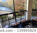 A restaurant with large windows offering views of the autumn foliage. 139993829