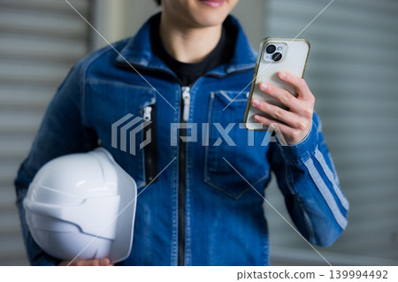 A young worker operating a smartphone A young worker operating a smartphone 139994492