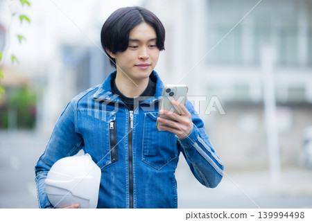 一位年輕員工正在操作智慧型手機 一位年輕員工正在操作智慧型手機 139994498