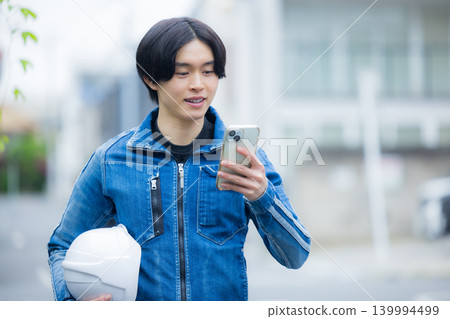 一位年輕員工正在操作智慧型手機 一位年輕員工正在操作智慧型手機 139994499