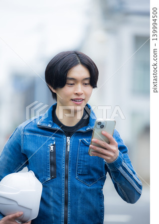 一位年輕員工正在操作智慧型手機 一位年輕員工正在操作智慧型手機 139994500