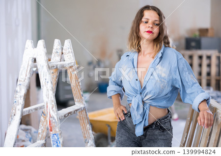 Tempting woman in revealing attire posing in construction site Tempting woman in revealing attire posing in construction site 139994824